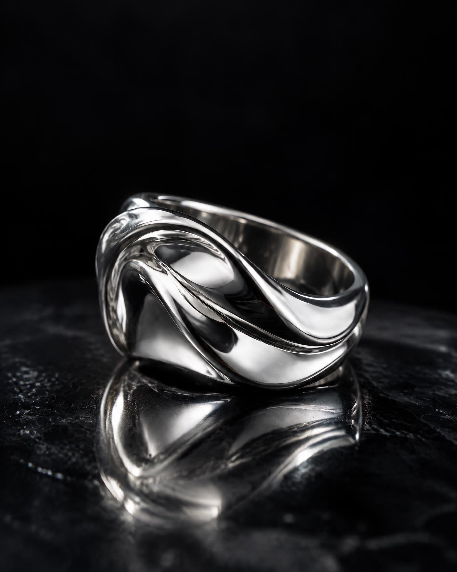 Sculptural silver ring on reflective glass